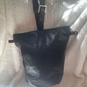 Acosta leather black bucket style shoulder bag with red stitching accents .